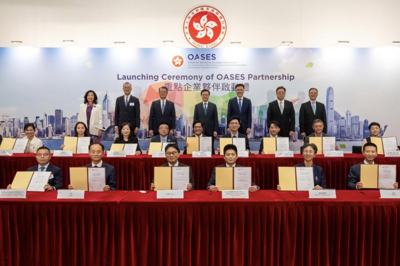 重點企業: 李家超(後排中)和陳茂波(後排左三)見證引進辦跟第一批在香港落戶或擴充業務的重點企業進行簽字儀式。 重點企業: 李家超(後排中)和陳茂波(後排左三)見證引進辦跟第一批在香港落戶或擴充業務的重點企業進行簽字儀式。