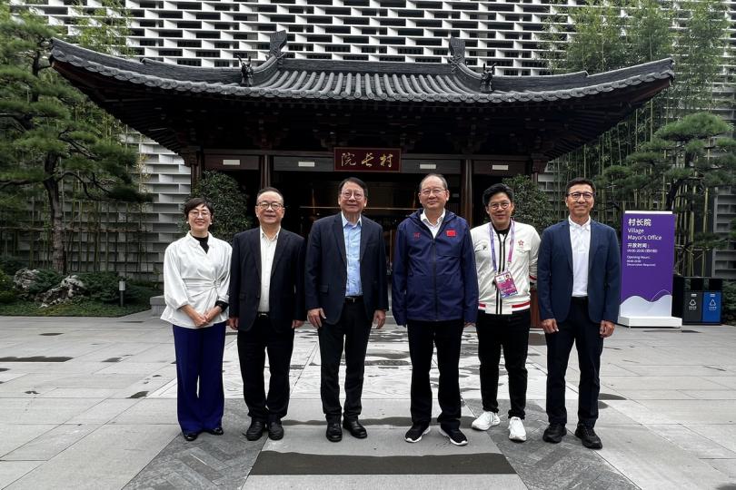 照顧健兒:  陳國基（左三）在杭州亞運會運動員村與李火林（右三）會面。
