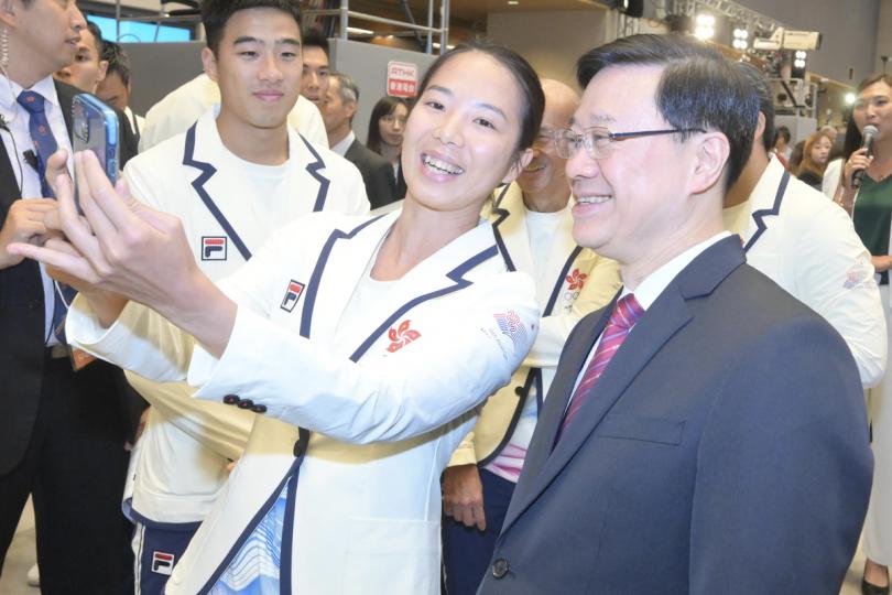 凱旋歸來:  李家超（右）出席第19屆亞運會中國香港代表團返港歡迎儀式。有運動員與他合照。
