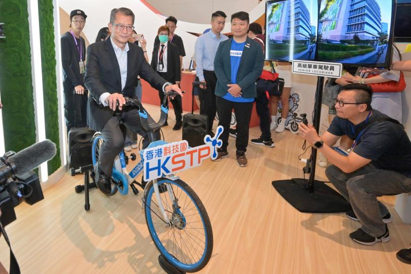 科研成果:  陳茂波（左二）體驗香港科技園公司的展品。