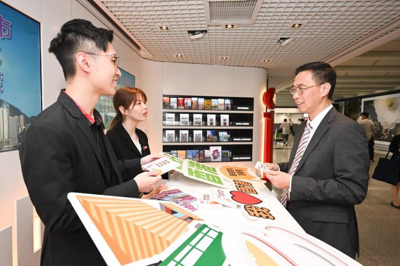 準備就緒:  楊潤雄（右）視察旅發局位於香港國際機場的旅客諮詢中心，聽取工作人員介紹相關準備工作。
