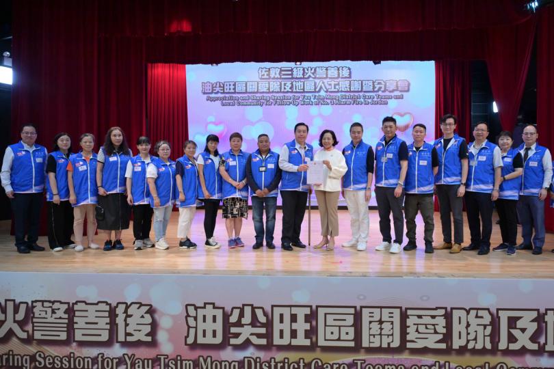 地區關懷:  麥美娟（右八）頒發感謝信予油尖旺區關愛隊。