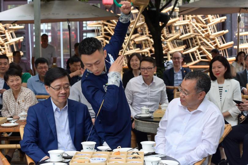 別具特色:  李家超（左）在普布頓珠陪同下到訪成都市人民公園，了解當地飲食文化。