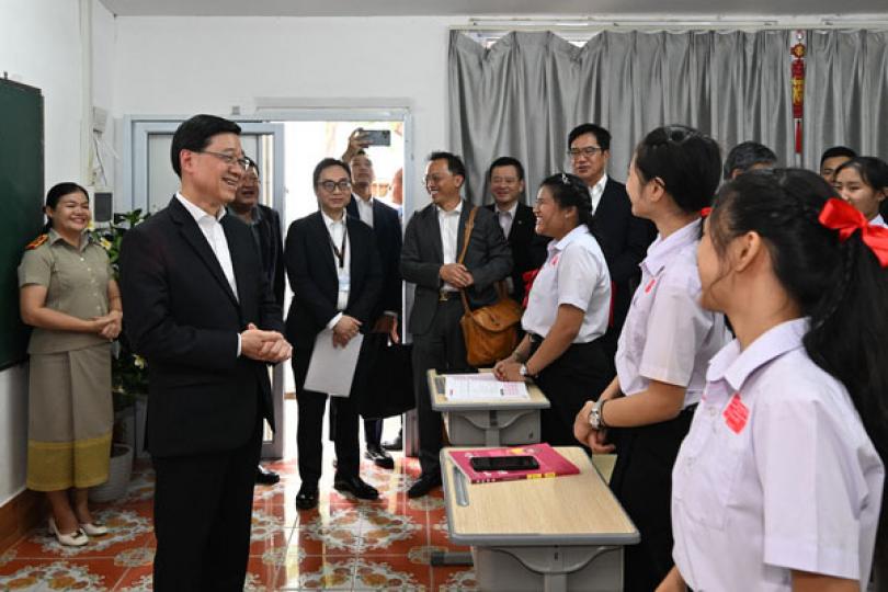 到訪學校: 李家超（左二）在老撾一所中學與學生交流。