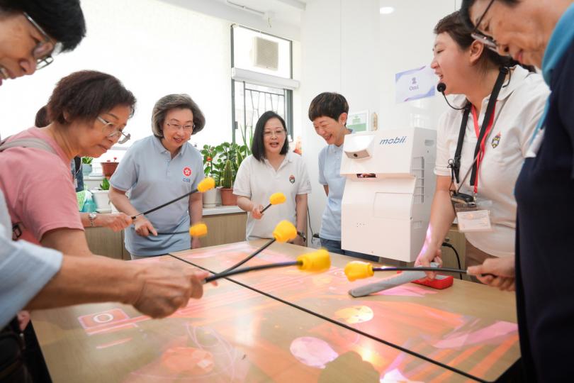 樂齡活動:  楊何蓓茵（右五）、公務員義工與長者一同參與感官統合訓練遊戲。