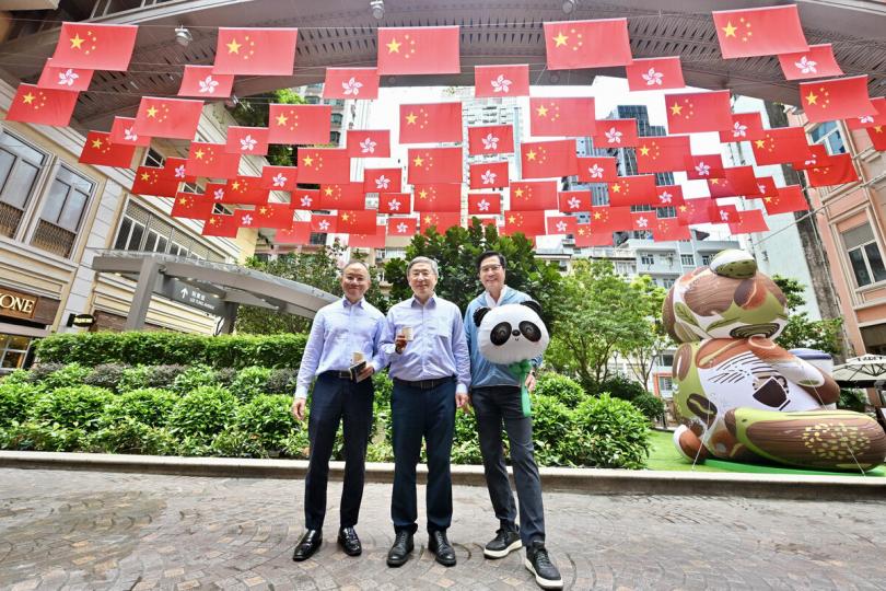 共慶回歸:  卓永興（中）、黃偉綸（右）和曾國衞在灣仔利東街旗海打卡。