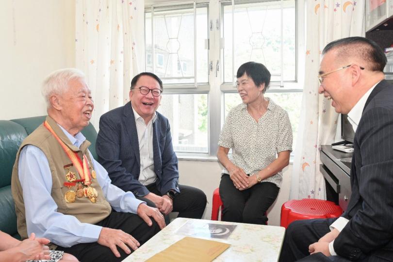 關懷慰問:  陳國基（左二）和劉光源（右一）與曾參加抗戰的老兵及其家屬交談。