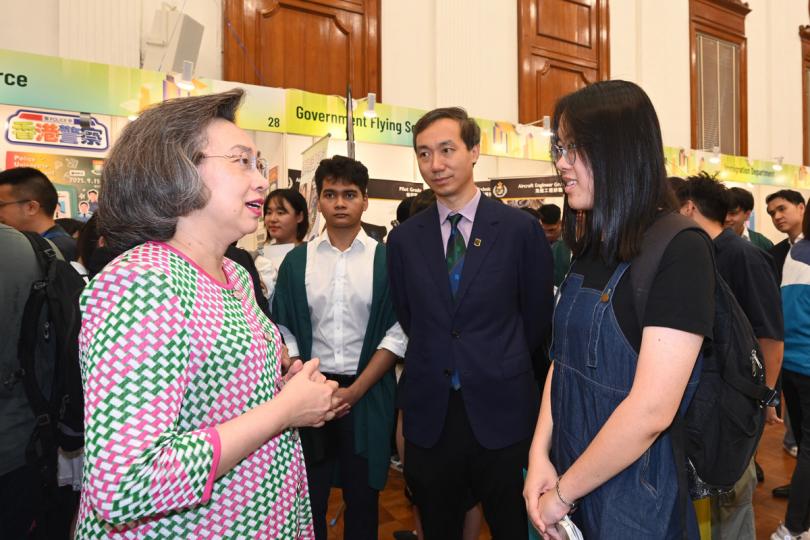 勉勵:  楊何蓓茵（左）出席在香港大學舉行的政府職位招聘展覽，並與學生交談。