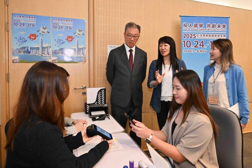 準備就緒:  陸啟康(後排左)視察位於添馬政府總部的選舉主任辦事處,了解繳交選舉按金的安排。 準備就緒:  陸啟康(後排左)視察位於添馬政府總部的選舉主任辦事處,了解繳交選舉按金的安排。