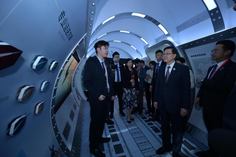 以客為先:  李家超（右二）在進博會參觀香港服務業展館，並與參展商交流。