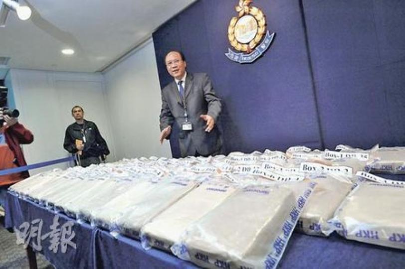 毒品調查科總警司李伯樂展示檢獲的70公斤可卡因。該批可卡因被壓成磚狀後再包上泥黃色砂紙，混入大批真磚之中偷運入境。（葉漢華攝）