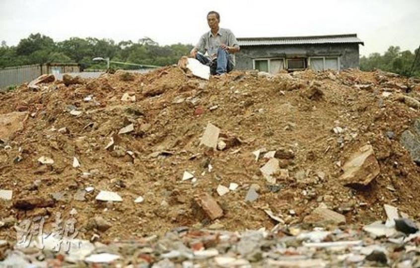 石湖圍村內一條通往附近大馬路的行人路，下雨過後儼如一條小河流，村民寸步難行。（余俊亮攝）