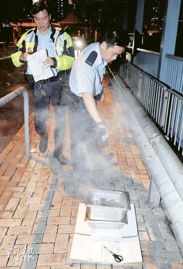 警員將車廂內盛炭的鐵盆搬出車外，用水將炭淋熄。（蔡方山攝）