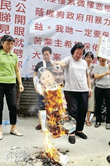請願者衝出馬路霸佔一條行車線靜坐，致交通擠塞，警方唯有開放有地陷危險的另一條行車線讓車輛行駛。（葉漢華攝）