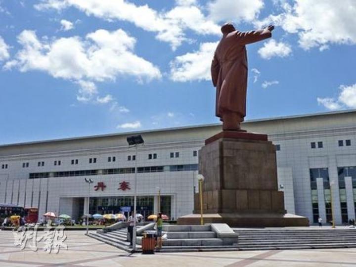 丹東不少人靠「朝鮮」招牌為生，圖為一名小販出售朝鮮錢幣。（明報記者攝）