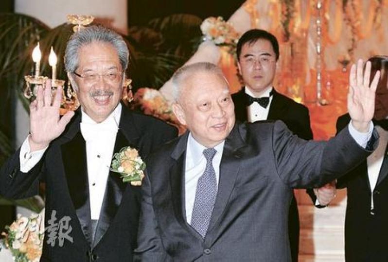 政務司長唐英年（右）昨日偕太太（左）出席黃宜弘幼子的婚禮，逗留了約半小時，於開席前離開。唐英年不時向傳媒微笑、點頭揮手，但對政改、七一等問題則未有回應。 （何家達攝）