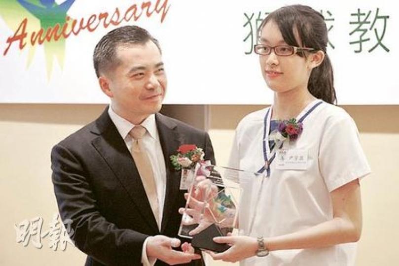 傑出學生之一中五生尹芳盈從律政司長黃仁龍手上接過獎座，她一年內參與1500小時義工活動，堅信「施比受更有福」。（李紹昌攝）