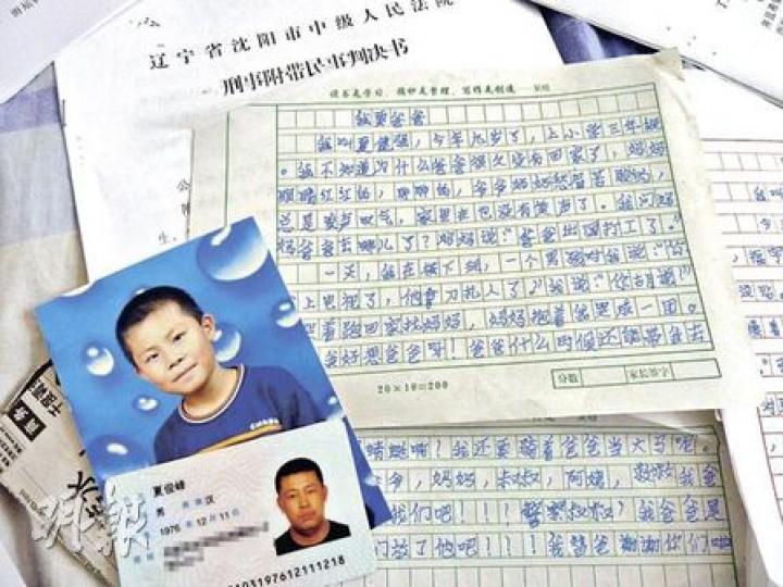 張晶拿着法院判處丈夫夏俊峰死刑的一審判決書。（明報記者攝）