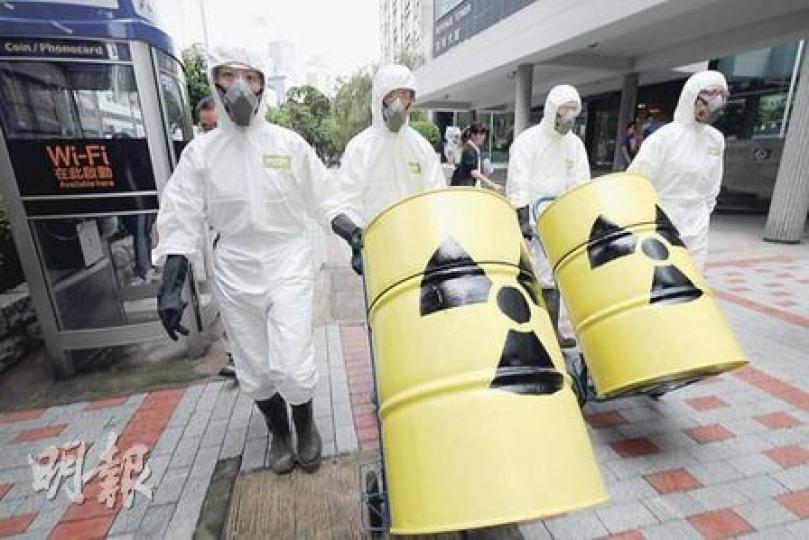 綠色和平成員昨日一身防化衣，將兩個象徵核廢料的鐵筒運至環境局，希望政府正視核廢料對環境的破壞。（陳智良攝）