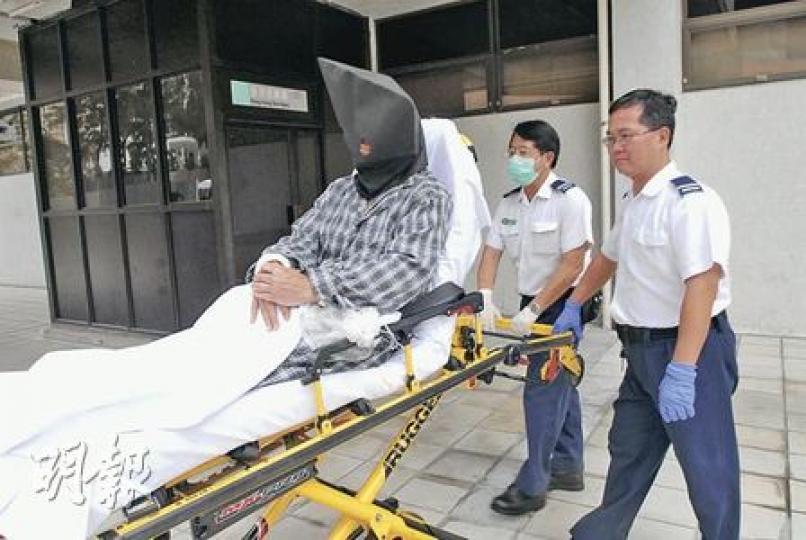 涉嫌在排頭村向妻子潑淋通渠水被捕的60歲疑犯，昨被落案起訴，黑布蒙頭由威爾斯醫院轉介至伊利沙伯醫院羈留。（劉友光攝）