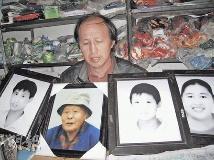 張明福手持遇難親人遺像，左為五弟張成福，左二為其母親，左三為五弟兒子、右一為五弟妻。張明福一年來不敢看家人遺照，拍照時亦盡量將目光移開，怕勾起傷心回憶。（明報記者攝）