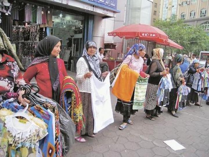 在烏魯木齊維族區二道橋附近，維族婦女在街邊兜售商品，但極少漢人幫襯。（明報記者攝）
