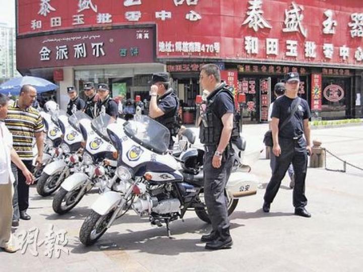 烏魯木齊巿面平靜，兩名維吾爾族少女在二道橋附近玩耍，拍照時不忘擺出「V」字手勢。（明報記者攝）
