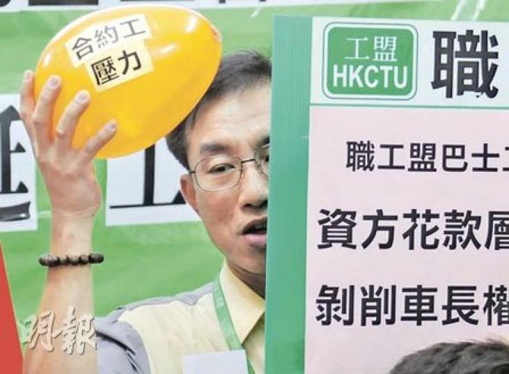 一名九巴司機高舉「合約工壓力」汽球，不滿前線員工卻未能得到合理待遇。（張智超攝）