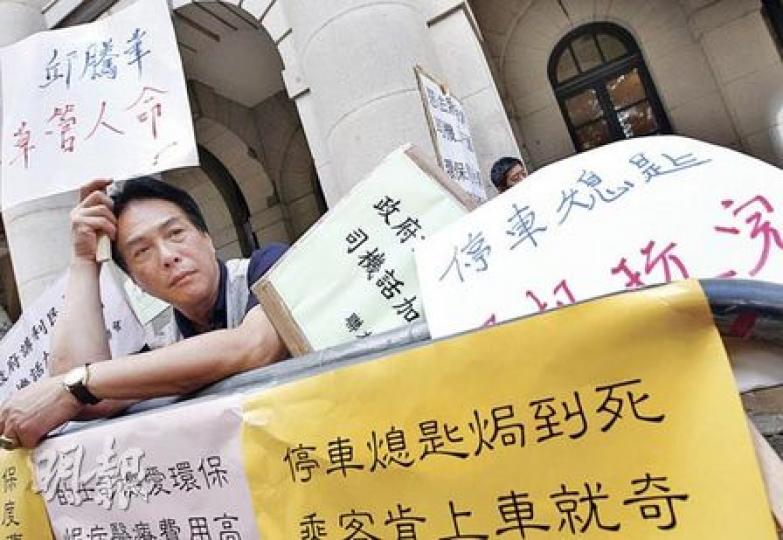 立法會昨繼續討論停車熄匙立法，約10多名的士及小巴司機代表到立法會外拉起橫額抗議，批評立法漠視職業司機健康。（李紹昌攝）小巴司機寧先生質疑，坐在辦公室的政府官員未有理會實際情况便推行停車熄匙，現在政府稱可在酷熱天氣及暴雨警告下轄免，「我們小市民亦無辦法」，只可以將就。（黃雄攝）的士司機邵先生指現今天氣異常，若氣溫22或23℃下停車熄匙，司機尚可忍耐。他指政府的讓步可以接受，但應再放寬一些，因為當氣溫超過27℃，他們已很熱，故希望超過27℃都不用停車熄匙。（黃雄攝）