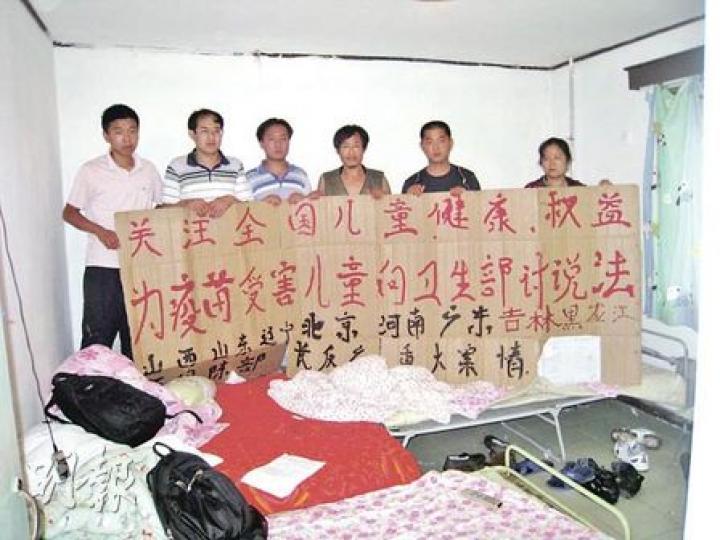 多名毒疫苗受害兒童家長在京上訪，向記者展示他們向衛生部的訴求。（明報記者攝）