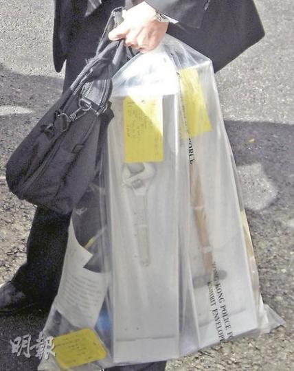 牧師之子柯雋揚承認毆打兩名同學，並以「點香灼身」和「飛槌」擊傷他們。圖為探員昨把涉案鐵槌及士巴拿送離法院。（吳光熙攝）