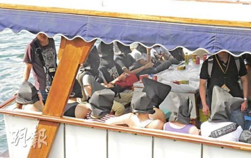艇內蒙頭 警方在西貢對開海面搗破遊艇毒品派對,拘捕25名青年及船主,被捕者黑布蒙頭坐在遊艇上,被押解上岸接受調查。(何朝財攝)26名被捕男女到西貢對面海水警基地登岸列隊接受調查。(何朝財攝)涉及「迷幻船河」案件的遊艇(左),由水警輪領航駛至西貢對面海水警基地。(何朝財攝) 艇內蒙頭 警方在西貢對開海面搗破遊艇毒品派對,拘捕25名青年及船主,被捕者黑布蒙頭坐在遊艇上,被押解上岸接受調查。(何朝財攝)26名被捕男女到西貢對面海水警基地登岸列隊接受調查。(何朝財攝)涉及「迷幻船河」案件的遊艇(左),由水警輪領航駛至西貢對面海水警基地。(何朝財攝)