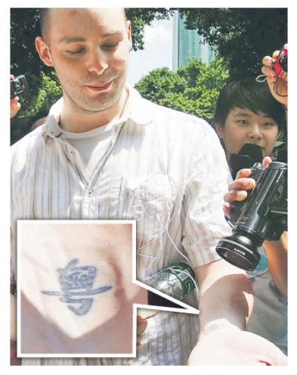 加拿大籍留學生向眾人展示其手腕上的「粵」字紋身（見小圖）。（明報記者攝）
