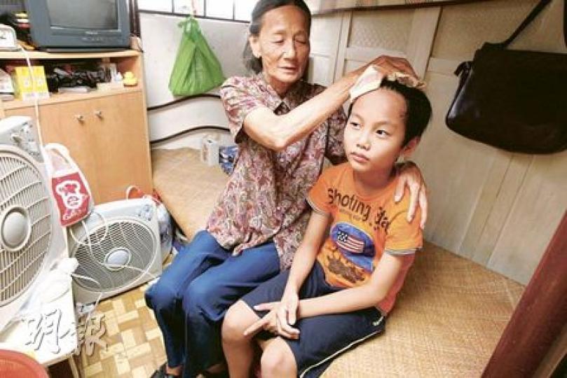 77歲的胡婆婆(左)與孫兒明仔(右)年多前開始搬進深水埗一個約30平方呎的板間房。踏入夏季,房內悶熱難耐,兩嫲孫每天流連附近商場避暑,至傍晚才回家,但房內晚上溫度仍然偏高,明仔指睡在房中猶如「煨番薯」。(李紹昌攝) 77歲的胡婆婆(左)與孫兒明仔(右)年多前開始搬進深水埗一個約30平方呎的板間房。踏入夏季,房內悶熱難耐,兩嫲孫每天流連附近商場避暑,至傍晚才回家,但房內晚上溫度仍然偏高,明仔指睡在房中猶如「煨番薯」。(李紹昌攝)