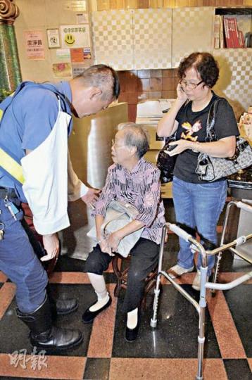 首先跌倒的83歲老婦手腳擦傷，事後坐在酒樓門口接受敷治。（胡永輝攝）