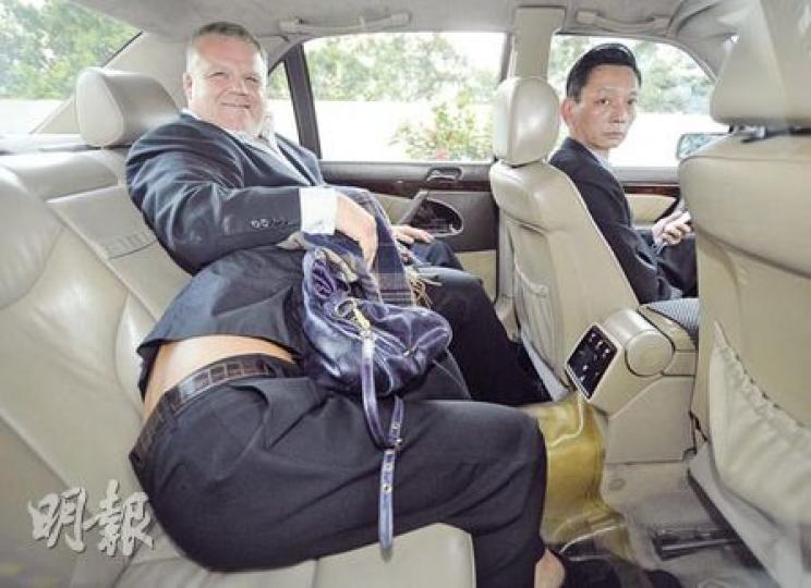 包致金侄女Amina由外籍保鑣護送，俯身慢行狼狽離庭。上車後，她俯伏保鑣大腿位置，保鑣則向記者面露笑容。（余俊亮攝）