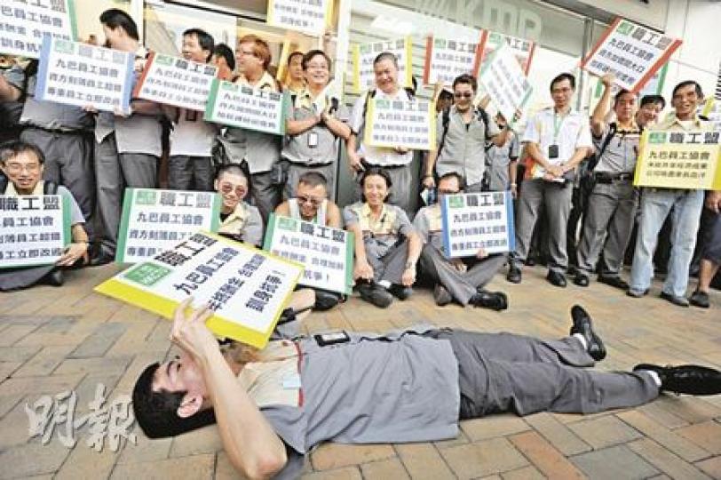 數十名九巴司機昨於荔枝角總部外請願，其中一名司機更一度橫臥地上帶頭叫口號，宣示「瞓身抗爭」。（尹錦恩攝）