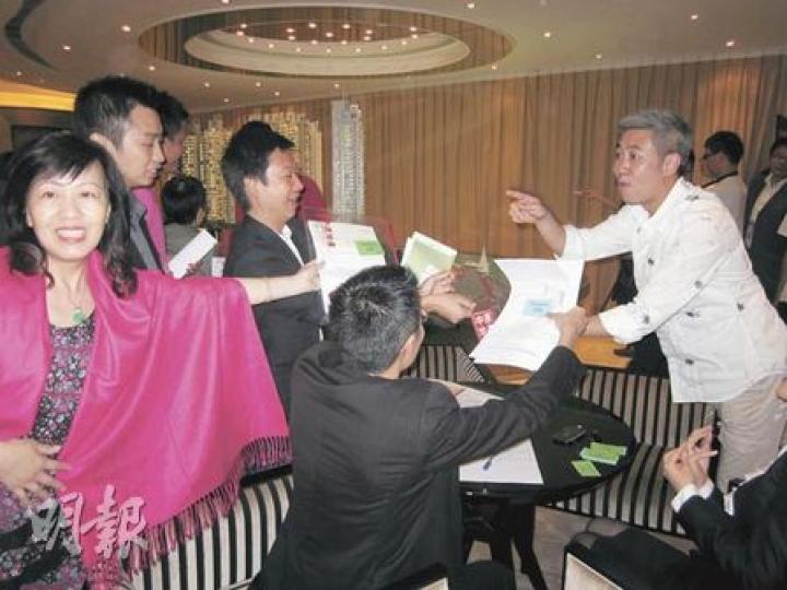 「南灣」昨日主力售賣1、2房單位,推出的66伙中,截至晚上8時已售出九成,亦即接近沽清。圖為售樓處內,地產代理爭相向主管遞交客人資料的情况。(林可為攝) 「南灣」昨日主力售賣1、2房單位,推出的66伙中,截至晚上8時已售出九成,亦即接近沽清。圖為售樓處內,地產代理爭相向主管遞交客人資料的情况。(林可為攝)