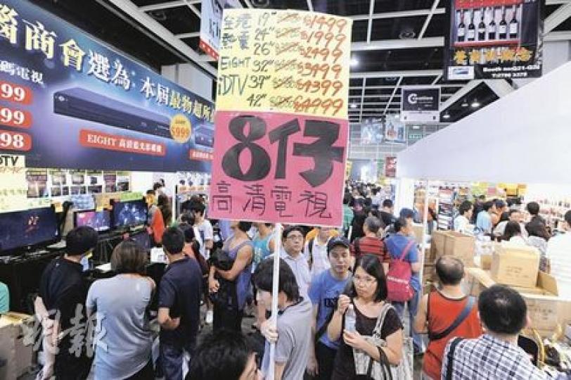 有電腦通訊節攤位負責人表示生意較往年差三四成，故提早割價銷貨，場內有不少「人肉廣告牌」推銷優惠貨。（尹錦恩攝）