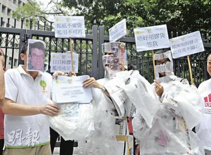 綠領行動聯同全港報販大聯盟約10名代表，昨發起「報紙不要袋」遊行，有代表全身覆蓋膠袋及報紙，要求政府盡快立法禁止出售報紙免費派膠袋。（陳淑安攝）