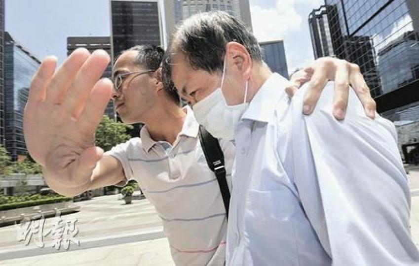 泥頭車司機王耀波（右）昨在友人護送下離開法院，他否認危險駕駛撞倒交通警凌小毅，令對方失去右腿。（余俊亮攝）