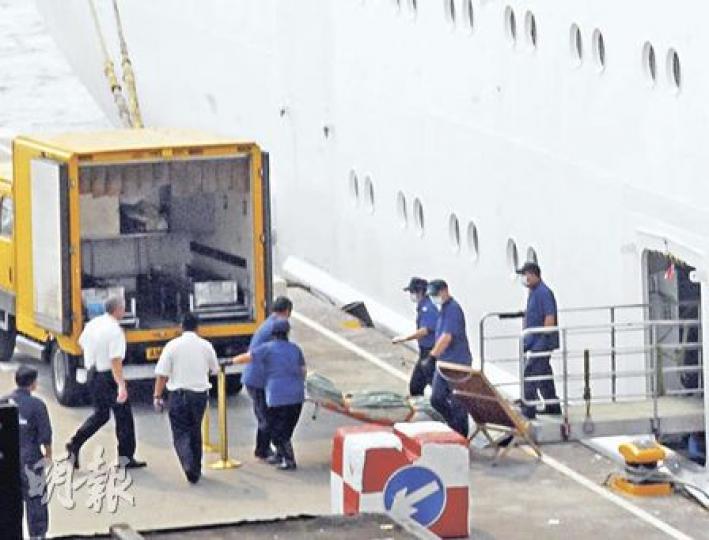 郵輪寶瓶星號回航途中有旅客墮海身亡，仵工事後到尖沙嘴海運大廈碼頭，將死者屍首舁送殮房，等候死者家人認領。（林錫禮攝）