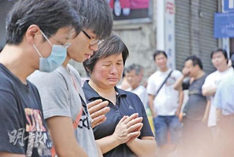 劉旭麟的家屬昨午到現場拜祭時，雙手合十神情哀傷。（屈俊樂攝）