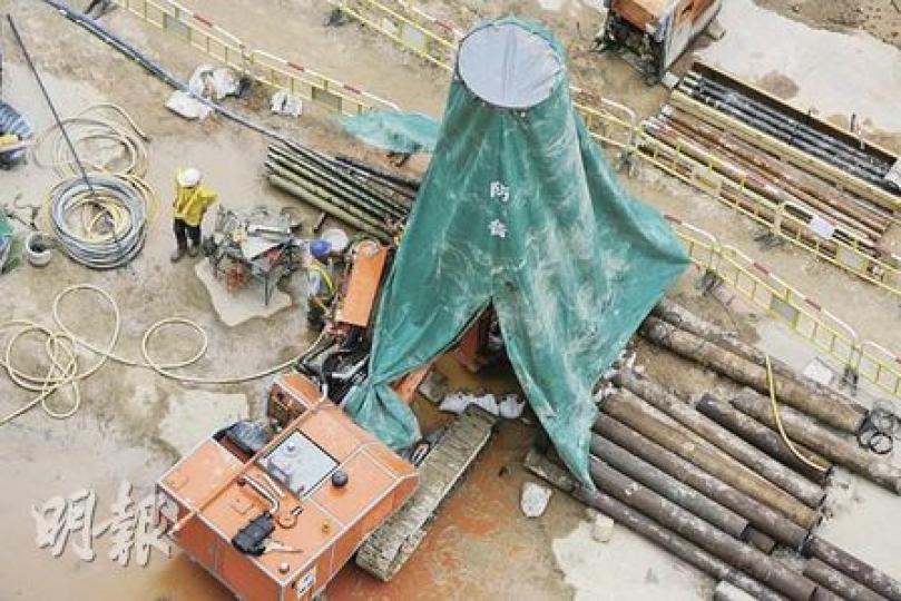 西港島線觀龍樓地盤的打樁機套上隔音罩,以減低噪音對附近居民的影響。(郭慶輝攝) 西港島線觀龍樓地盤的打樁機套上隔音罩,以減低噪音對附近居民的影響。(郭慶輝攝)