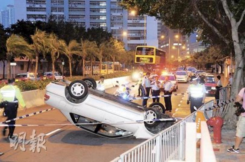 私家車在小西灣道失事掃毁鐵欄、撞撼大樹後，返彈回路中四輪朝天。（蔡方山攝）