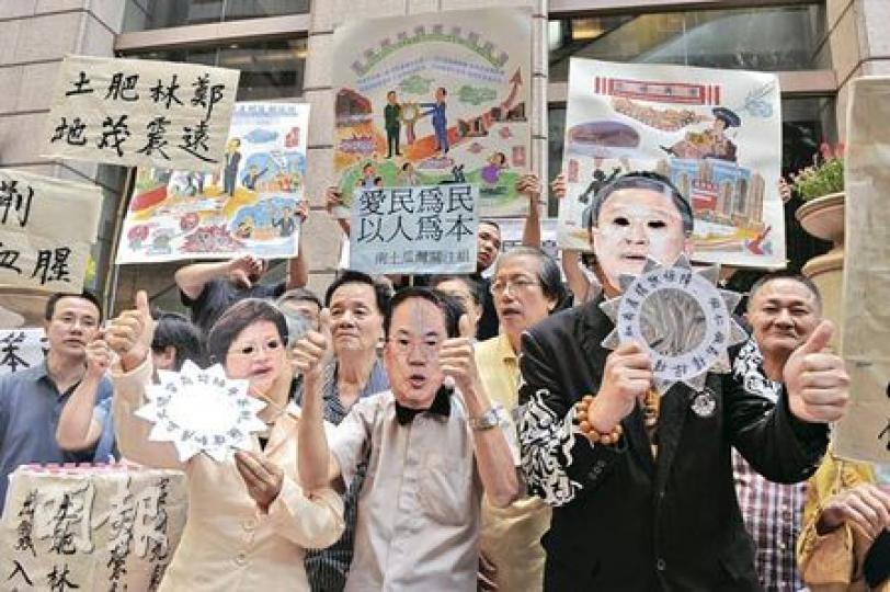 政府就新的市區重建策略展開諮詢，包括提出「樓換樓」安排，一班關注重建區業主權益的組織提出56項質疑，包括質疑並非真的「樓換樓」，因為舊樓業主被迫放棄高空發展權，還要在7年樓齡的補償中補上差價才能買到這些單位。他們昨戴上特首曾蔭權、發展局長林鄭月娥和市建局主席張震遠的面具上演街頭劇，諷刺有關官員不理小業主權益。（劉焌陶攝）