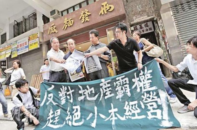 政府降低強拍門檻後，舊樓小業主投訴發展商收樓手法明顯增加，強制樓宇拍賣苦主大聯盟成員王浩賢批評，政府至今仍未有支援小業主的措施，使強拍條例對社區造成災難。他（右二）昨日與「兩發麵廠」3名掌舵人楊氏三兄弟（左二至左四）向傳媒披露麵廠困境。（余俊亮攝）兩發麵廠樓上的住宅單位已被麗新發展收回業權，從圖中可見，麵廠樓上空置單位的窗戶一直打開，任由雨水飄進室內。（余俊亮攝）