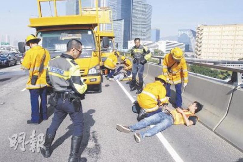 觀塘繞道的泥頭車串燒工程車意外中，兩名工人走避不及受傷，躺在路邊等候救援。（劉友光攝）風琴箭嘴車司機（右二）及載水箱工程車司機（左一）向警員講述事發經過。（劉友光攝）（明報製圖）