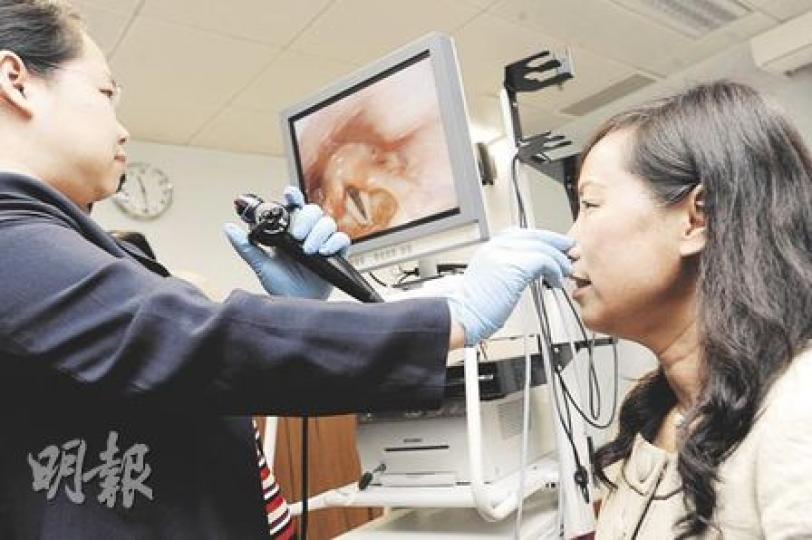 中大耳鼻咽喉－頭頸外科學系名譽臨牀助理教授何雅兒（左）用高清光纖內視鏡為韋靜嫺校長（右）檢查聲帶，結果顯示聲帶健康。（尹錦恩攝）