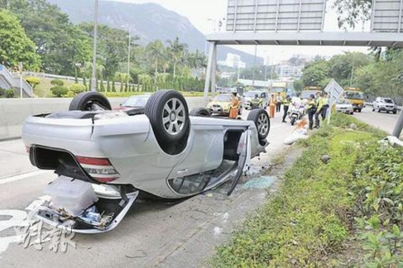 平治S系豪華房車失控鏟上花槽飛起，撞塌兩個路牌和一支燈柱後，飛彈15米至花槽另一邊行車線翻轉停下。（林錫禮攝）